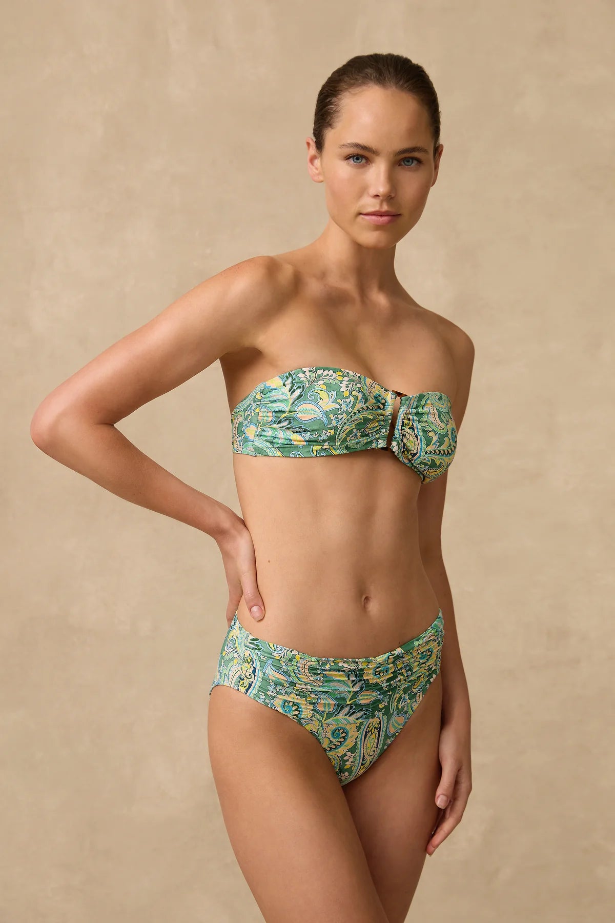 The Lulu Mid Rise Ruched Bikini Pant features a wide ruched front waist panel with fuller coverage through the front length and a higher cut leg that visually elongates the thigh.
