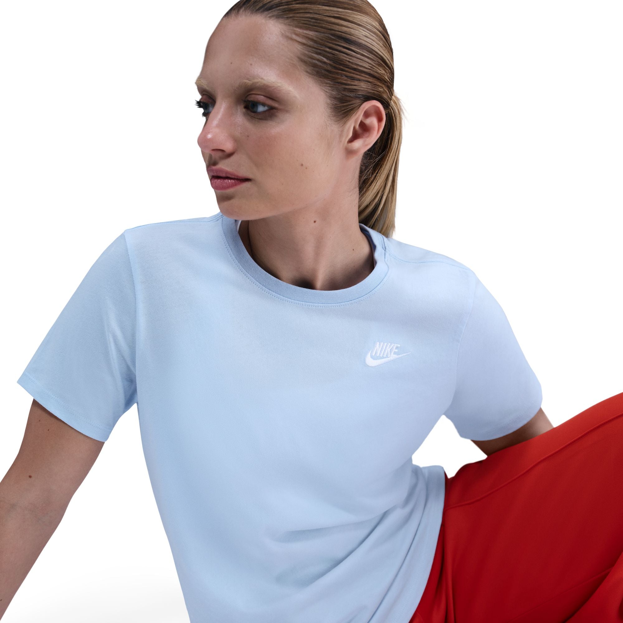 Woman wearing a light blue t-shirt with a Nike logo on a white background