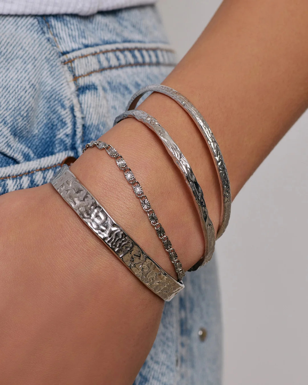 Crafted with a cool crushed silver texture and a refined, malleable shape, the Helios Cuff is the epitome of understated luxury
