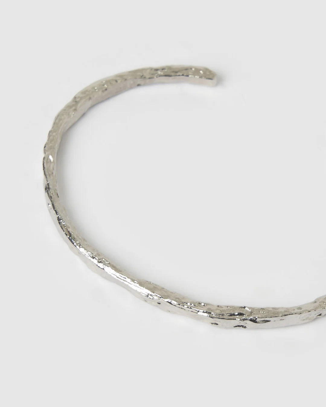 Crafted with a cool crushed silver texture and a refined, malleable shape, the Helios Cuff is the epitome of understated luxury