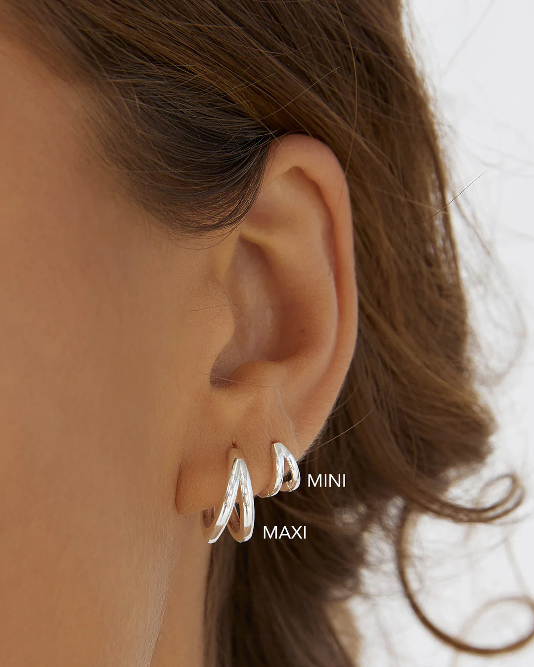 Designed as huggie-style hoops, they fit snugly on the ear, making them ideal for small lobes or second piercings. Featuring a simple double hoop design, these trendy earrings add the perfect finishing touch to any look.