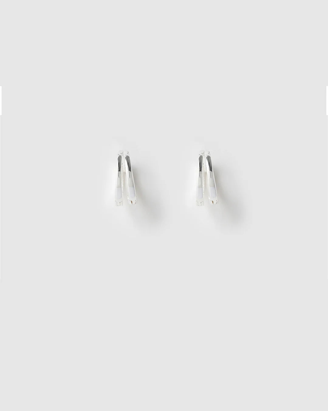 Designed as huggie-style hoops, they fit snugly on the ear, making them ideal for small lobes or second piercings. Featuring a simple double hoop design, these trendy earrings add the perfect finishing touch to any look.