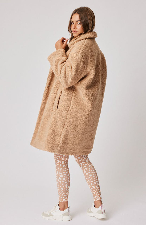 Oversized knee length coat with notched collar Feature black tortoise buttons on the front Front side pockets 100% faux sherpa fabric Leilani wears a size medium and is 177cm tall 