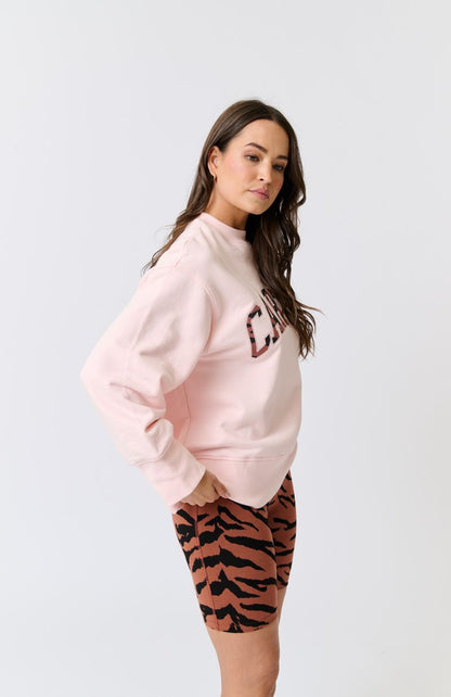 Hip length, relaxed fit sweater
Dropped shoulder gives an effortless look
Ribbed neckline, sleeve cuffs and waistband
Oversized, wide sleeve and cuff
Large Rust Zebra Leppard filled collegiate logo with pink embroidery
100% cotton terry fabric