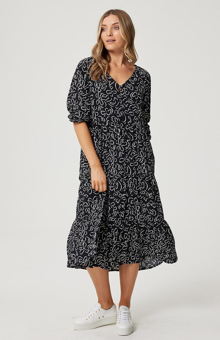 Smock style midi dress 3 Gathered tiers add fullness Long blouson sleeve with elasticated cuff Cartel and Willow exclusive hand drawn 'Black Stencil' print 100% rayon fabric