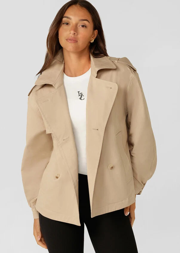 Elevate your active living wardrobe with the Cropped Sports Trench! Made from a premium cotton-blend twill, this breathable and versatile outerwear piece is designed with adaptability in mind. Featuring snap-off removable hoods and an easy double-breasted button-through opening, you can customize your look with ease. With roomy side pockets to stash your essentials, this trench is an essential addition to your capsule wardrobe.