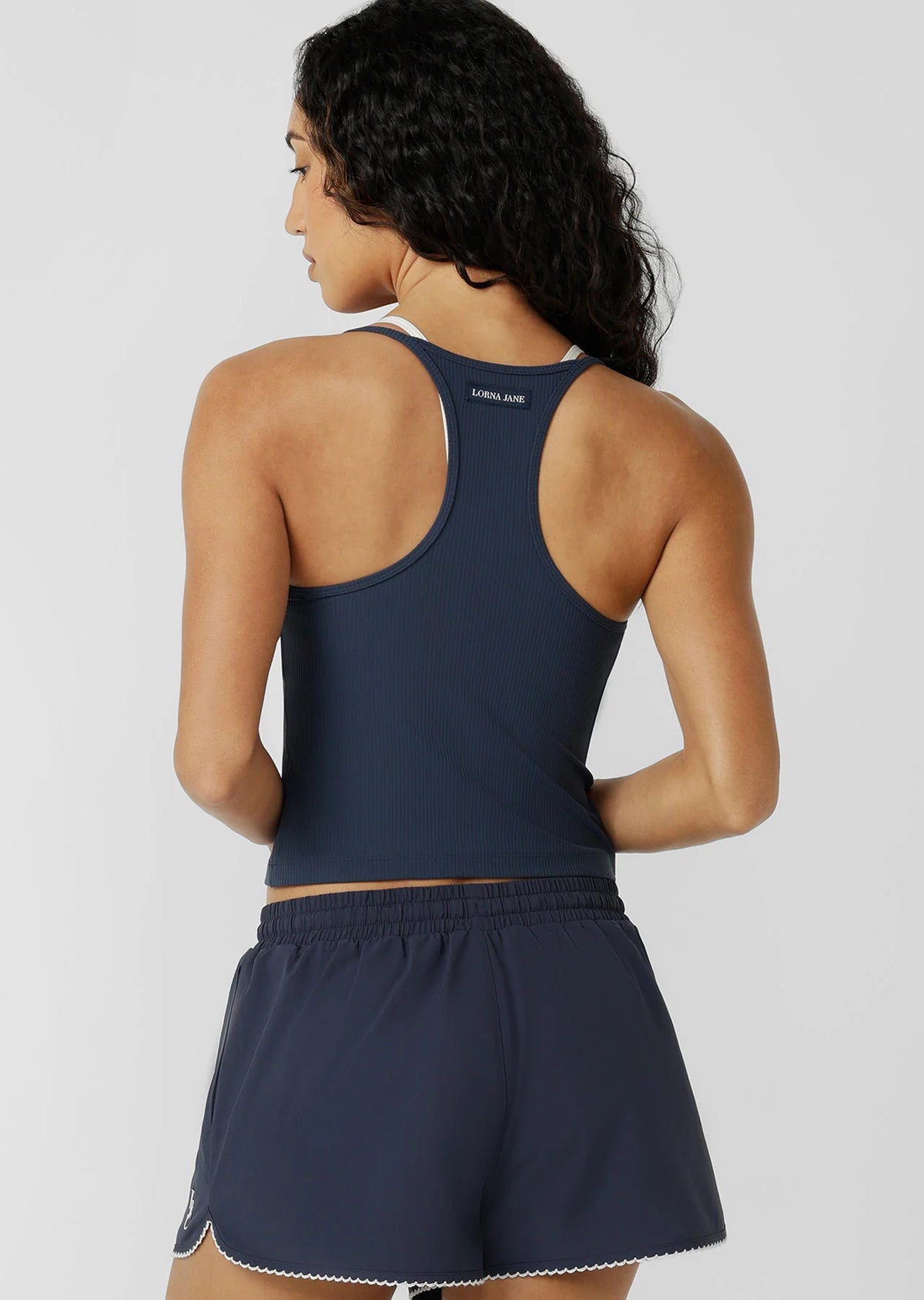 Built In Shelf Bra with Removable Padding for All Day Support
Fashion Forward Layered Look Design
Form Flattering Full Length Fitted Silhouette
Sweat wicking Luxe Active Rib Fabrication
Woven Logo Badge
