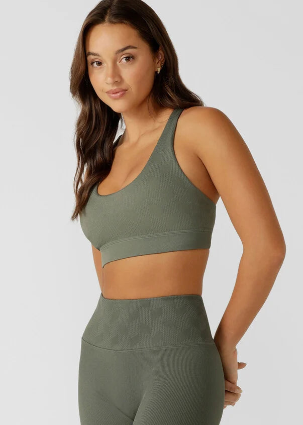 Elevate your workout game in this seamless sports bra. Designed for all day support, this bra offers a seamless fit that moves with you, while providing a stylish and unique look that will make you stand out in any class or crowd.