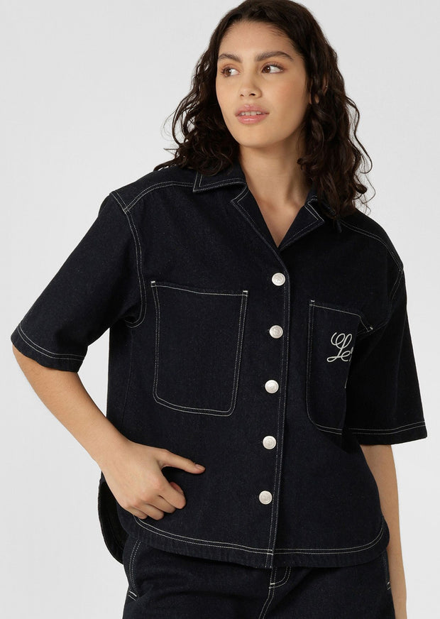 Elevate your everyday look with this slightly cropped and loose-fitting denim overshirt. Featuring contrast stitching, a classic button-through closure, and elevated embroidered detailing on the chest pocket, this shirt is bound to become your new wardrobe essential! 