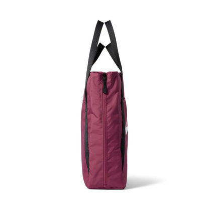 A side profile view of a burgundy tote bag with black shoulder straps and black side accents, shown against a plain white background.