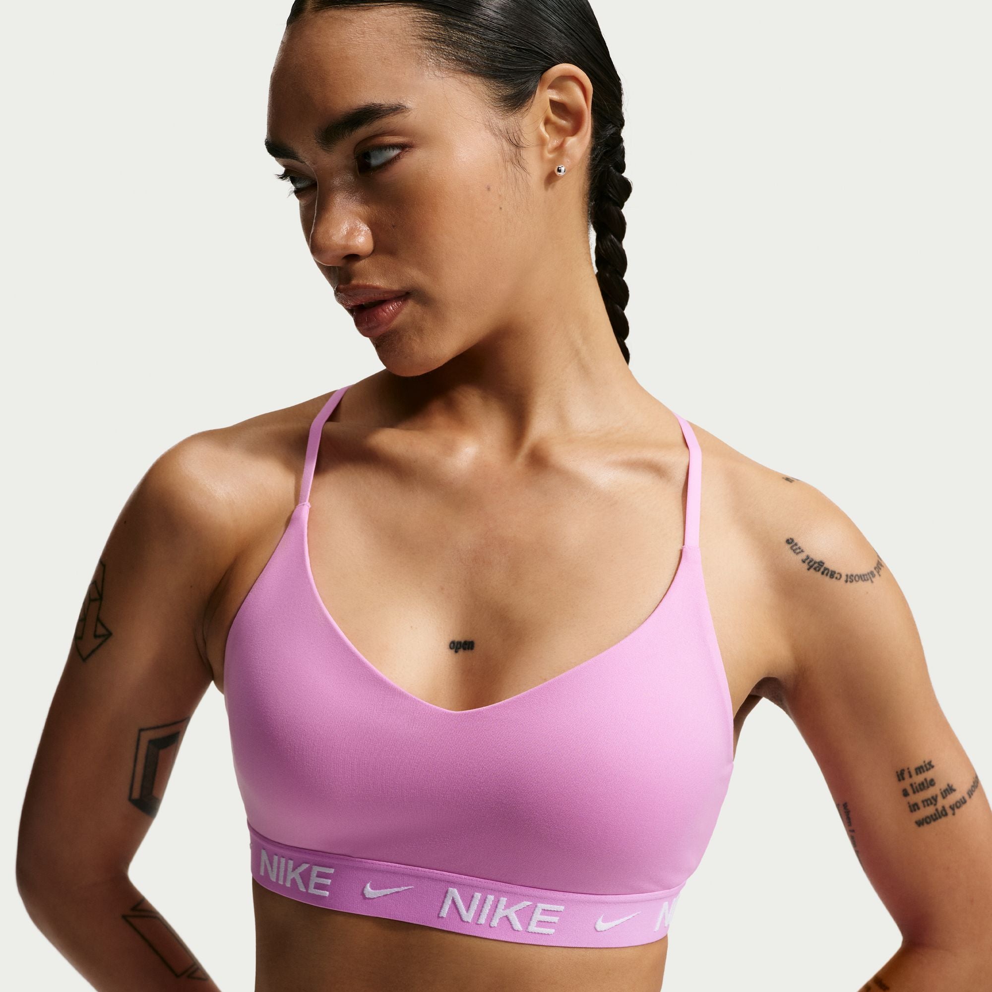 Woman wearing a pink Nike sports bra against a plain background