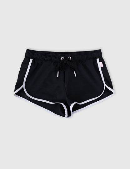 Seafolly Girls Essentials Boardshort in Black features an elasticated waistband, draw cord, scallop hemline, contrast piping.