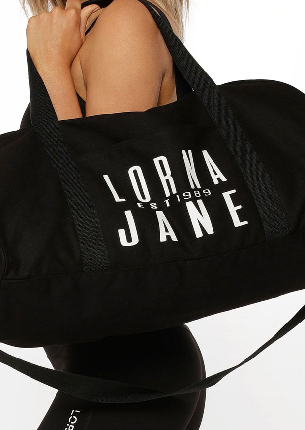 Finally! A duffle bag that pulls its weight in style as much as it does gym gear. In three iconic colours with bold Lorna Jane graphics, no longer will ‘girl-on-the-go’ gift ideas evade you.  Features: Exterior Pocket Detachable and Adjustable Strap Zip Closure  Fabric: 100% Cotton